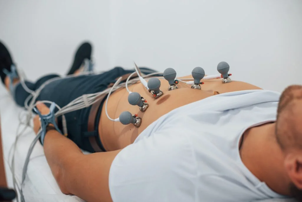 Man lying on the bed in the clinic and getting electrocardiogram test